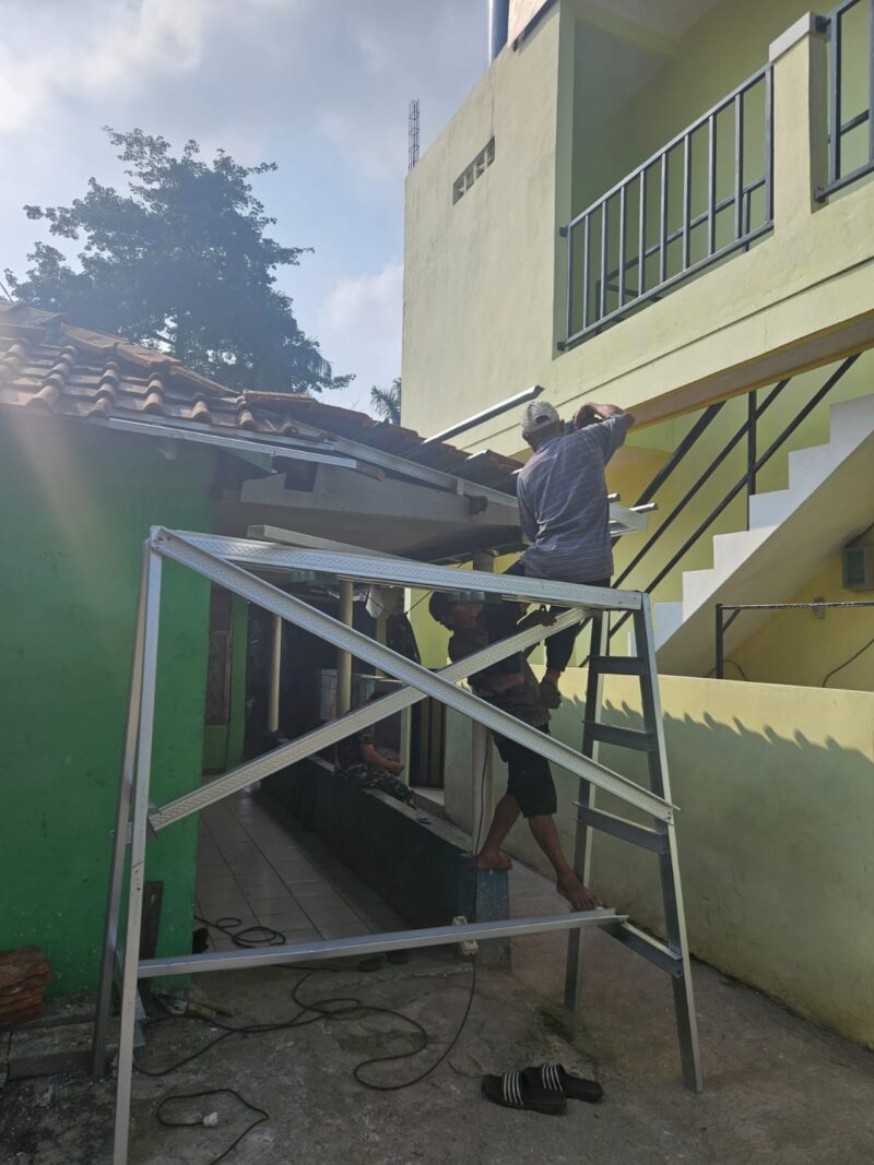 Babinsa Bersama Warga Gotong Royong Pasang Genteng untuk Pembangunan Rumah

